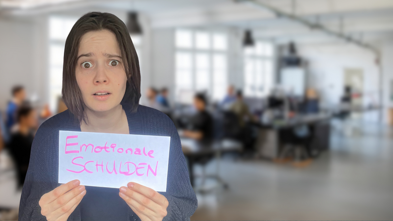 Katharina Rupp hält ein Schild mit der Aufschrift Emotionale Schulden